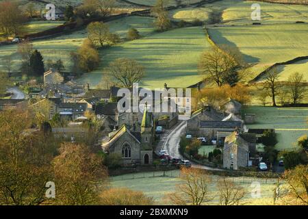Burnsall (scenic Yorkshire Dales village) in valley, attractive cottages, country lane, green hillside fields (sunny winter morning) - England, GB, UK