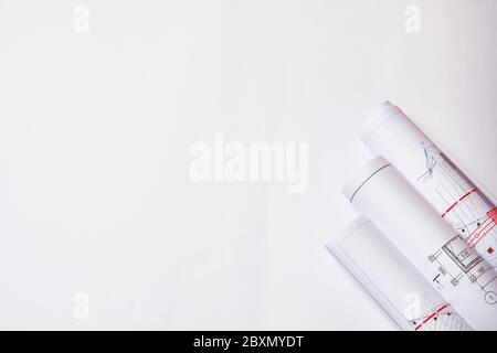 Rolled engineering drawings at white background with copy space. Stock Photo