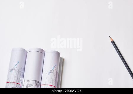 Rolled engineering drawings and pencil at blank white background with copy space. Stock Photo