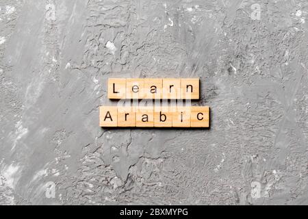 learn arabic word written on wood block. learn arabic text on table, concept. Stock Photo