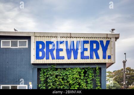 Old rusty brewery sign at Oamaru in the South Island of New Zealand. Omaru is home to the steam punk. Stock Photo