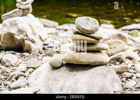smooth pebbles tower closeup on river bank in summer Stock Photo