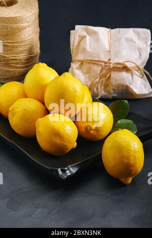 Lemons on a gray background behind the material for packaging products. Close up, ecological packaging. Delivery of products, copies of space, photos Stock Photo