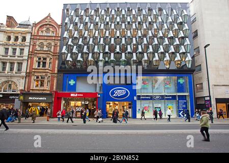 People walking past McDonalds, Boots and Muji stores on Oxford Street, Soho, London Stock Photo