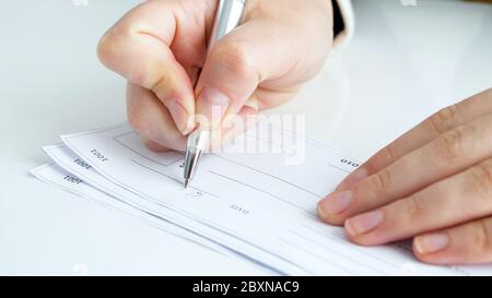 Closeup image of person signing banking cheque Stock Photo