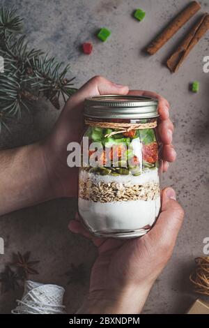 Christmas cookie mix jar. Dry ingredients for cooking Christmas cookies in a jar, dark background. Christmas food concept. Stock Photo