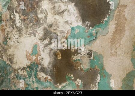 Brick wall. Old flaky white paint peeling off a grungy cracked wall. Cracks, scrapes, peeling old paint and plaster on background of old cement wall. Stock Photo