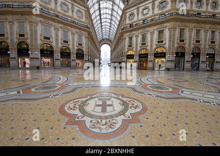 The emptiness of Galleria Vittorio Emanuele with shops closed during the lockdown caused by the Covid-19 in Milan, Italy. Stock Photo