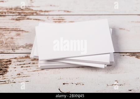 Mock up blank white business cards on light rustic natural wooden background. Stock Photo