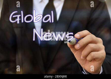 Businessman hand writing Global News on virtual screen. Idea for business and technology. Stock Photo