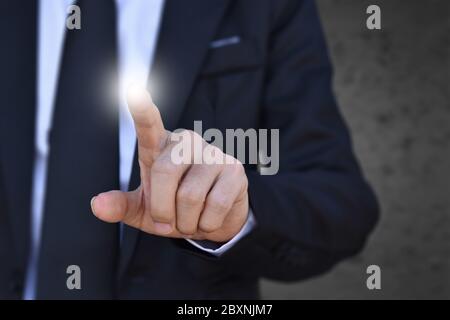 Businessman finger pressing an imaginary screen. Idea for business, technology, internet and networking. Stock Photo