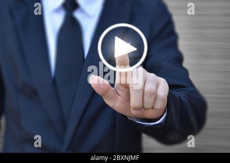 Businessman pressing play button to start. Idea for business, technology and presentation. Stock Photo