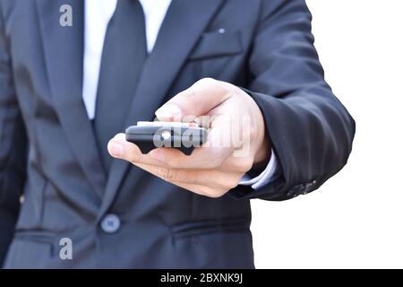 Businessman hand holding black remote control isolated on white background. with clipping path. Stock Photo