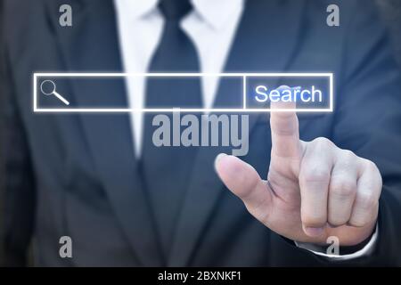 Businessman clicking internet search page on virtual screen. Concept of searching with pressing button. Stock Photo