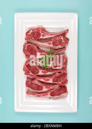 Lamb chops on a plate isolated against a blue background Stock Photo