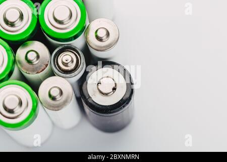 many new and used alkaline batteries type AA on a light background. Stock Photo