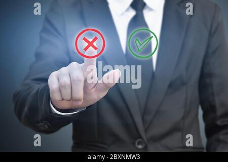 Businessman pressing touch screen right and wrong icon. Idea for about technology and choices business. Stock Photo