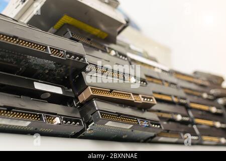 a lot of hard drives from the computer are on the top shelf of the rack against the background of the white ceiling Stock Photo