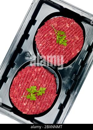 Burger patties in a supermarket packaging tray isolated on a white background Stock Photo