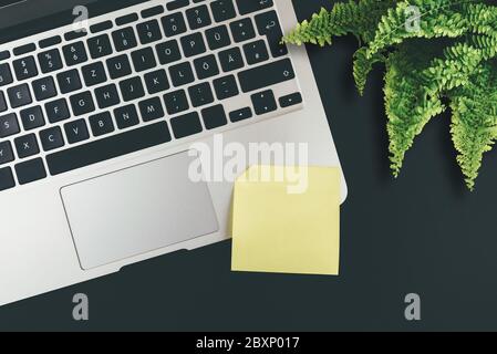 above view of empty yellow adhesive note on laptop keyboard Stock Photo