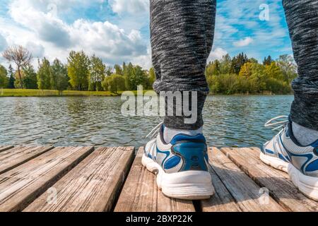 Man standing on the edge of wooden dock with beautiful landscape Stock Photo