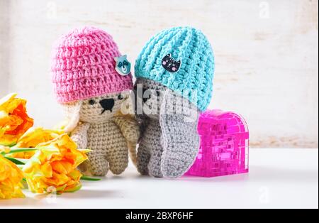 Handmade crochet rabbit toys on green background. Amigurumi doll. Selective focus Stock Photo