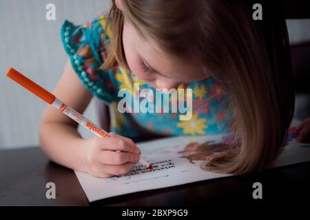 A 5-year-old girl uses felt tip crayons Stock Photo