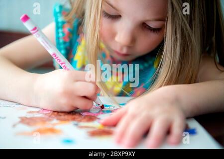 A 5-year-old girl uses felt tip crayons