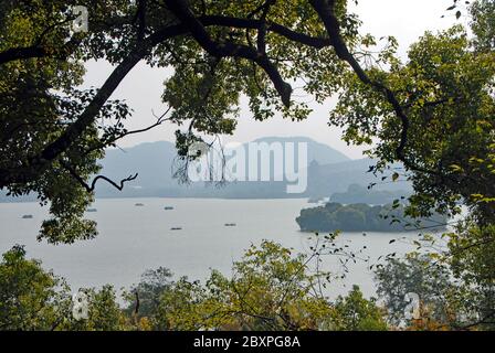 West Lake (Xi Hu) in Hangzhou, Zhejiang Province, China. View through the trees towards Leifeng Pagoda from Gushan Hill on the shore of West Lake Stock Photo