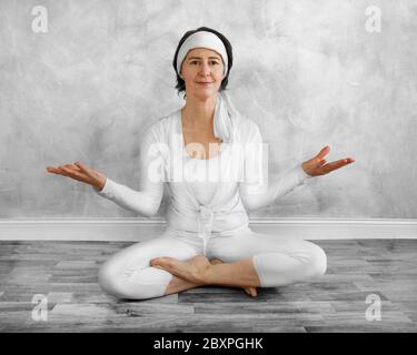 A seated woman practicing meditation indoors Stock Photo