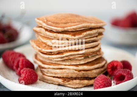 Stack of whole wheat pancakes with raspberries on plate, selective focus Stock Photo