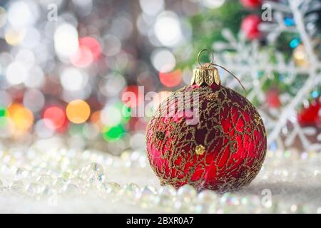 Christmas red ball on artificial snow, defocused background, selective focus Stock Photo