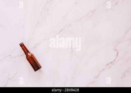 Single beer bottle laying on a marble background with plenty of copy space Stock Photo