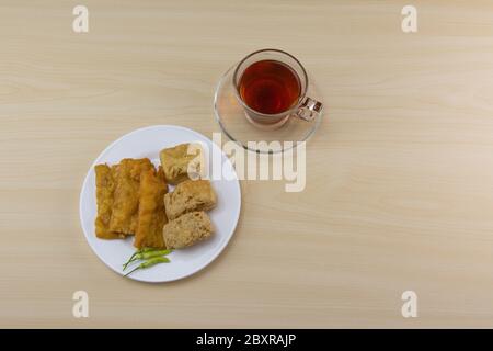 Fried tempeh and tofu with a cup of hot tea for a healthy breakfast. Stock Photo