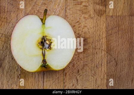 Close up of half red apple fruit on a wooden background Stock Photo