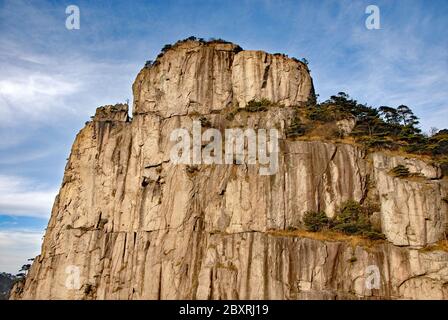 Huangshan Mountain in Anhui Province, China. Viewpoint near Fairy Walking Bridge on Huangshan. View of a steep cliff with pine trees. Stock Photo