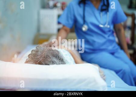 Asian nurse physiotherapist doctor care, help and support senior or elderly old lady woman patient at hospital ward : healthy strong medical concept. Stock Photo