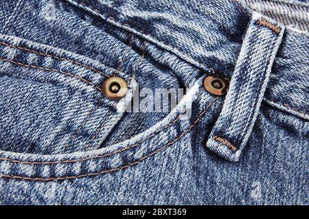 Blue jeans close up detail showing front pocket and waist band and belt loop and studs Stock Photo