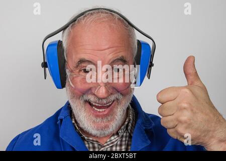 Laughing, old, experienced craftsmen always play it safe and put on hearing protection and safety glasses. Stock Photo