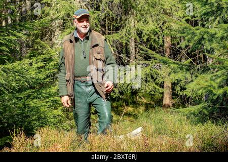 On a beautiful spring morning an old hunter walks through his hunting ground in the Black Forest and enjoys the beautiful spring day. Stock Photo