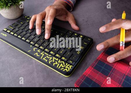 Close up of young man in casual dress hand typing on keyboard  Stock Photo