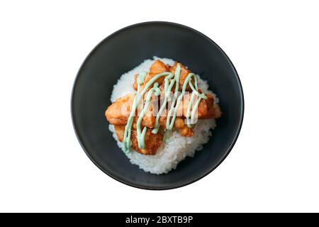 Kara-age wasabi done (fried chicken tipping with wasabi sauce on the rice) in a black bowl is isolated and topview side on white background. Clipping Stock Photo