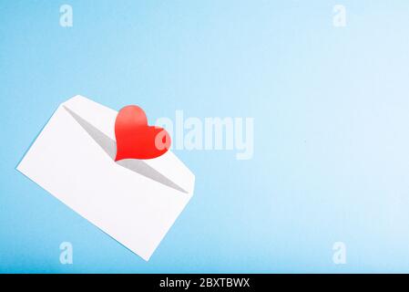 Open envelope and red paper heart on a blue background with place for text Stock Photo