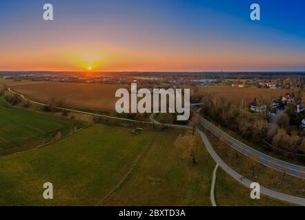 Beautiful sunset behind a bavarian village with a field in the foreground. Stock Photo