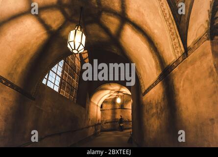 light from the lamp and the shadows in the mysterious corridor in the old dungeon in the castle Stock Photo