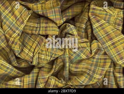 Chaotic folded green checkered fabric background. A detailed shot of the texture of natural fabric in green shades. Multitask background. Selective fo Stock Photo