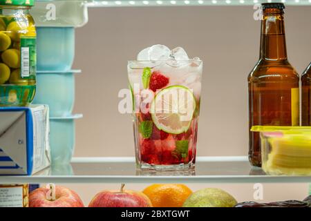 Raspberry mojito cocktail in a fridge. Close up. Cold, fresh and vegan drink.  Stock Photo
