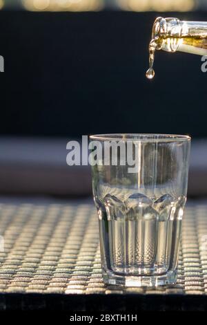 Beer drop falling down to the glass. Freezing motion. Bar, pub, restaurant concept. Copy space, grey background.  Stock Photo