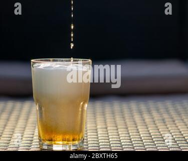 Beer drop falling down to the glass. Freezing motion. Bar, pub, restaurant concept. Copy space, grey background.  Stock Photo