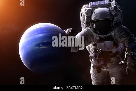 Neptune on a blurred background with a giant astronaut. Solar system Stock Photo